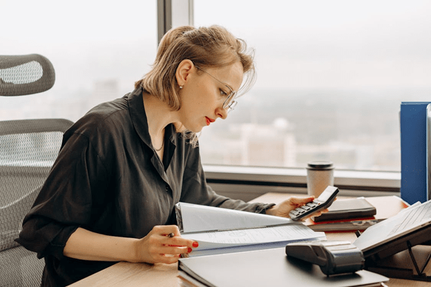 women in polo long sleeve using a calculator